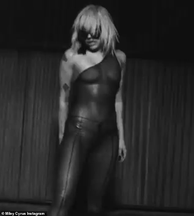 Cyrus looked decent in a sheer jumpsuit that she wore in a black and white clip