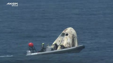 Recovery crews approach the Crew Dragon capsule after landing.