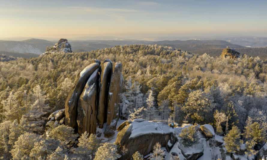 Snow-covered rock formations surrounded by forests