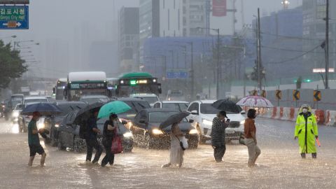 Pedestrians cross a flooded road in Gimpo, Seoul, on August 9.