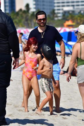 Miami, Florida - Scott Disick is a happy dad as we pick up the star spending time with his three kids Penelope, Mason and Wren in Miami.  Scott cruises in the water with his daughter Penelope and younger son Rain (who wears a Squid gaming mask) while Mason relaxes on a beach chair.  Pictured: Scott Disick, Penelope Disick, Rain Disick Backgrid USA Feb 22, 2022 USA: +1 310798 9111 / usasales@backgrid.com UK: +44208344 2007 / uksales@backgrid.com *UK Customers - Pictures Containing children Please Pixelate the face before posting *