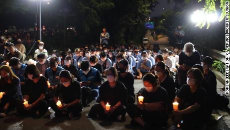 A small crowd holds a candlelight vigil in Seoul on August 11 to commemorate the death of a family after their home was inundated with a flood on August 8.