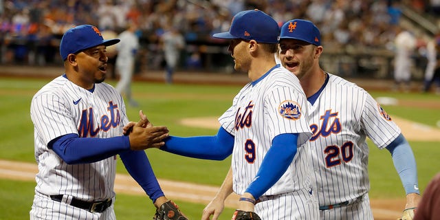 Eduardo Escobar #10 and Pete Alonso #20 of the New York Mets congratulate teammate Brandon Nemo #9 after the seventh inning against the Los Angeles Dodgers at Citi Field on August 31, 2022 in New York City.  Nimmo made a home savings catch in the first half.
