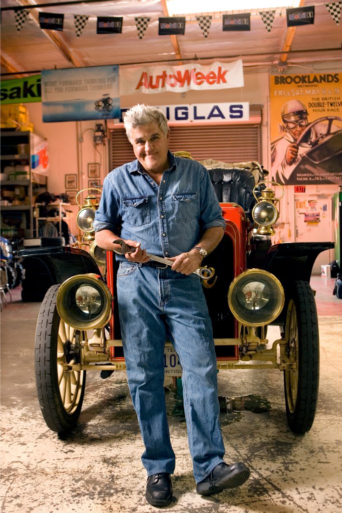Picture of Jay Leno standing in front of his car.