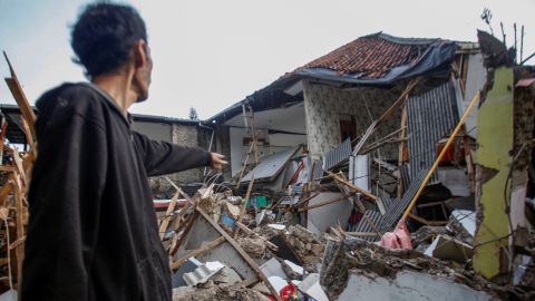 A man stands near houses damaged after the earthquake that hit Cianjur, West Java Province, Indonesia, November 21, 2022.